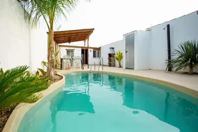 a swimming pool in the middle of a house at Villa casa blanca luxury spa con piscina privada y jacuzzi privado in Chiclana de la Frontera
