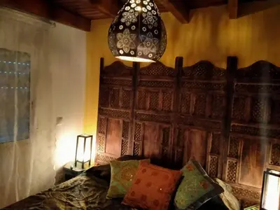 a bedroom with a bed with a wooden headboard and a lamp at Villa casa blanca luxury spa con piscina privada y jacuzzi privado in Chiclana de la Frontera