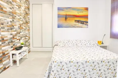 a bedroom with a bed and a painting on the wall at Chalet Puente Tabla in Conil de la Frontera