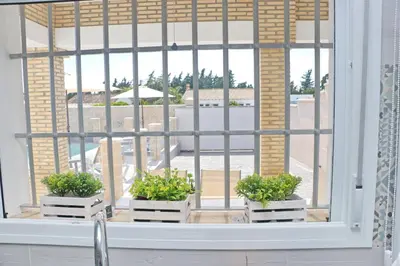 a window with three potted plants on a window sill at Chalet Puente Tabla in Conil de la Frontera