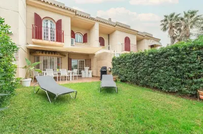 a house with two lawn chairs in the yard at Casa Don Camilo Costa Ballena in Costa Ballena