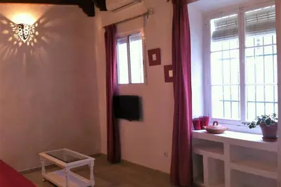 a living room with a television and a window at Casa Florinda #1 in Jerez de la Frontera