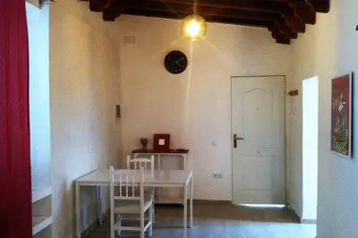 a dining room with a table and chairs and a clock on the wall at Casa Florinda #1 in Jerez de la Frontera