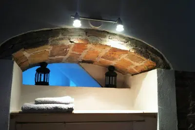 a bathroom with a brick arch with towels on a shelf at Casa Florinda #1 in Jerez de la Frontera