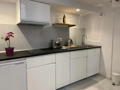 a kitchen with white cabinets and a sink at San Lorenzo Apartamentos y Suites in Cádiz