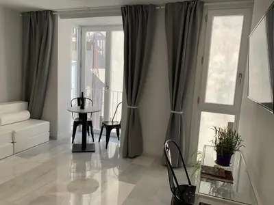 a living room with a table and a window at San Lorenzo Apartamentos y Suites in Cádiz