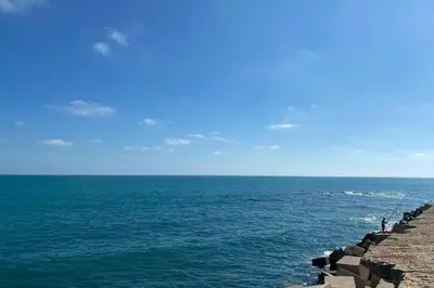 a group of people standing on the edge of the ocean at Mirador Playa Caleta Cádiz Centro Grupo AC Gestion in Cádiz