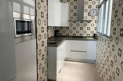 a small kitchen with white cabinets and a microwave at Mirador Playa Caleta Cádiz Centro Grupo AC Gestion in Cádiz