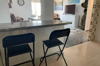 a kitchen with two chairs sitting at a counter at Mirador Playa Caleta Cádiz Centro Grupo AC Gestion in Cádiz