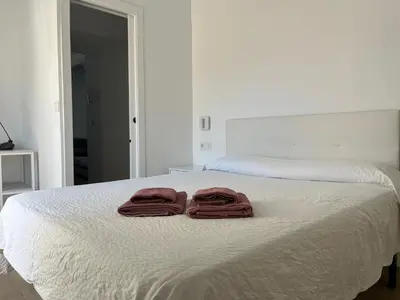 two towels sitting on top of a white bed at Plaza Libertad Grupo AC Gestion in Cádiz