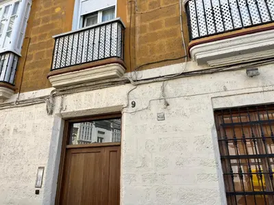 a building with a wooden door and a balcony at Plaza Libertad Grupo AC Gestion in Cádiz