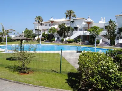 a tennis court in front of a large building at Novo Sancti Petri Atardecer planta primera in Chiclana de la Frontera