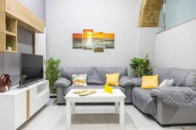 a living room with a couch and a tv at Apartamento Barrocal by Cadiz Time in Cádiz