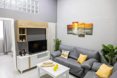 a living room with a couch and a tv at Apartamento Barrocal by Cadiz Time in Cádiz