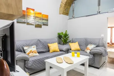 a living room with a couch and a table at Apartamento Barrocal by Cadiz Time in Cádiz