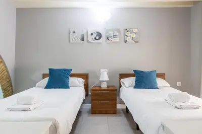 two beds in a room with blue pillows on them at Apartamento Barrocal by Cadiz Time in Cádiz