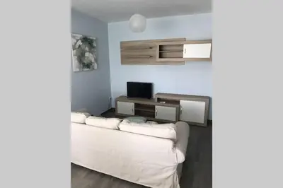 a living room with a white couch and a television at CASA MARINA DE LA BAHIA in Puerto Real