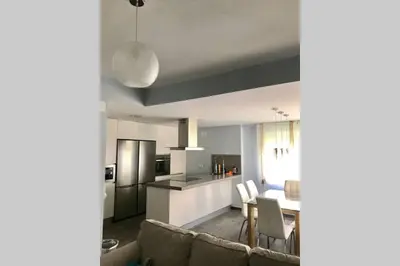 a kitchen and a living room with a table and chairs at CASA MARINA DE LA BAHIA in Puerto Real