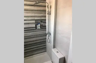 a bathroom with a white toilet and a shower at CASA MARINA DE LA BAHIA in Puerto Real