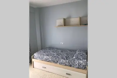 a small bedroom with a bed and shelves at CASA MARINA DE LA BAHIA in Puerto Real
