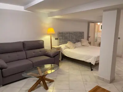 a living room with a couch and a bed at Altair 11 in El Puerto de Santa María