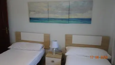 a bedroom with two beds and a painting on the wall at Apartamento Fenicia con aparcamiento incluido Vistas al mar in Cádiz