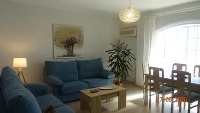 a living room with a blue couch and a table at Apartamento Fenicia con aparcamiento incluido Vistas al mar in Cádiz