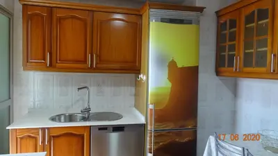 a kitchen with wooden cabinets and a sink at Apartamento Fenicia con aparcamiento incluido Vistas al mar in Cádiz