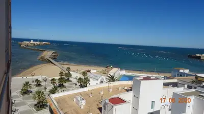 a view of a beach and the ocean from a building at Apartamento Fenicia con aparcamiento incluido Vistas al mar in Cádiz