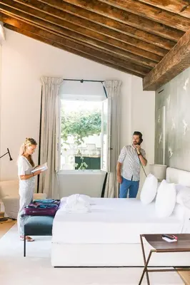 a man and a woman standing in a room with a bed at Hotel Bodega Tio Pepe in Jerez de la Frontera