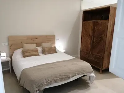 a bedroom with a large bed and a wooden cabinet at LOFTS MIRIAM CONDE O,REILLY in Cádiz