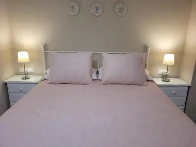a bedroom with a bed with two pink pillows at Novo Sancti Petri - Playa, Piscina, Golf y Relax in Chiclana de la Frontera