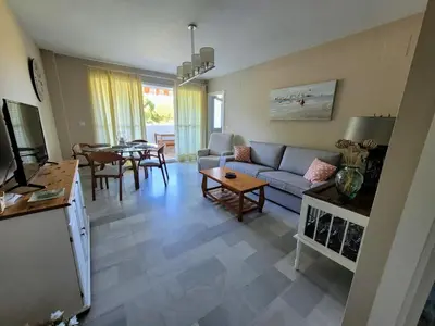 a living room with a couch and a table at Novo Sancti Petri - Playa, Piscina, Golf y Relax in Chiclana de la Frontera