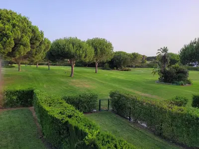 a view of a park with a gate and trees at Novo Sancti Petri - Playa, Piscina, Golf y Relax in Chiclana de la Frontera