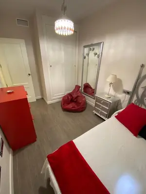 a bedroom with a red and white bed and a mirror at Beautiful & Cozy Apart. Pool & Parking-Downtown in Sanlúcar de Barrameda