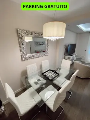 a dining room with a glass table and white chairs at Beautiful & Cozy Apart. Pool & Parking-Downtown in Sanlúcar de Barrameda