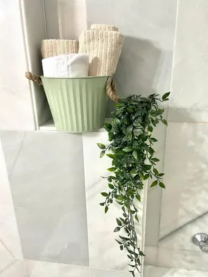 a green plant sitting next to a shelf with towels at GATU Villa Cielo y Mar junto la playa, terraza , wifi y vista al mar ,