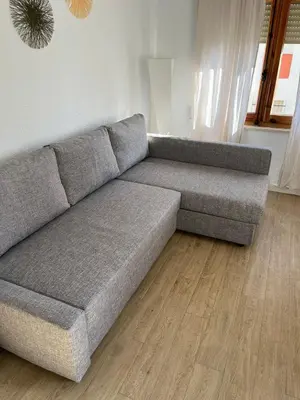a gray couch in a living room with a wooden floor at GATU Villa Cielo y Mar junto la playa, terraza , wifi y vista al mar ,