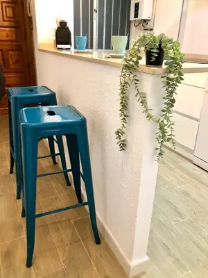 two blue stools next to a counter with a plant at GATU Villa Cielo y Mar junto la playa, terraza , wifi y vista al mar ,