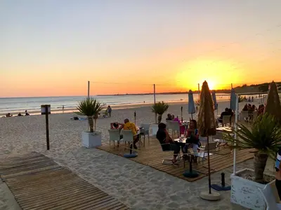 a group of people sitting at tables on the beach at GATU Villa Cielo y Mar junto la playa, terraza , wifi y vista al mar ,