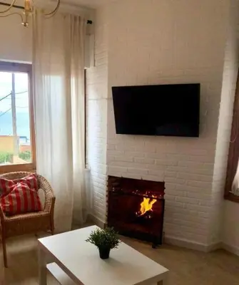 a living room with a fireplace with a television above it at GATU Villa Cielo y Mar junto la playa, terraza , wifi y vista al mar ,