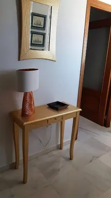a table with a lamp on top of it at Bonito Ático en el centro de la ciudad in Sanlúcar de Barrameda
