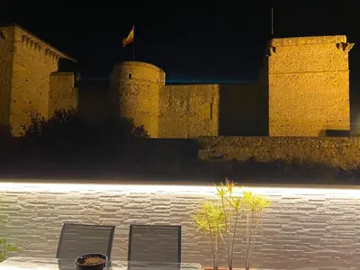 two chairs in front of a castle at night at Bonito Ático en el centro de la ciudad in Sanlúcar de Barrameda