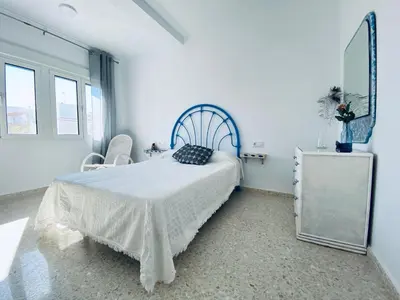 a white bedroom with a bed and a mirror at Ramón y Cajal 6 in Chipiona