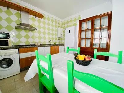 a kitchen with a table with a bowl of fruit on it at Ramón y Cajal 6 in Chipiona