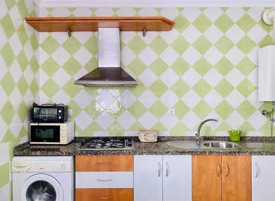 a kitchen with a stove top oven next to a sink at Ramón y Cajal 6 in Chipiona