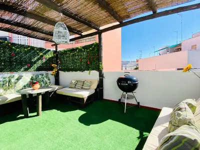 a patio with a couch and a table on a balcony at Ramón y Cajal 6 in Chipiona