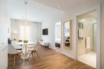 a dining room and living room with a table and chairs at Tandem Puerto Chico in Cádiz