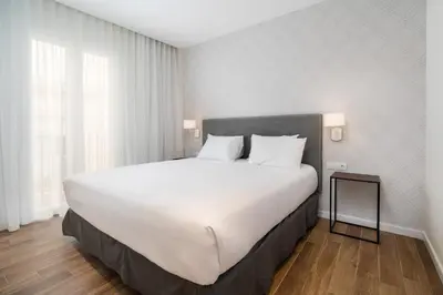 a bedroom with a large bed with white sheets and pillows at Tandem Puerto Chico in Cádiz