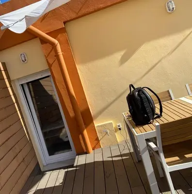 a backpack sitting on a wooden bench on a porch at Atico Loft The Rose 48 in Cádiz